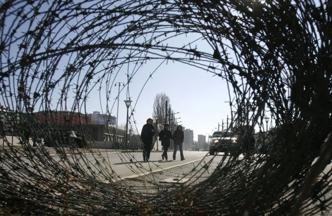 Women are seen behind barbed wire, as they cross a bridge from the Albanian side to the Serb side in the ethnically divided Kosovo town of Mitrovica February 14, 2008. Serbia will not allow itself to be humiliated by a "puppet state" on its territory, Prime Minister Vojislav Kostunica said on Thursday as Serbia prepared to annul Kosovo's proclamation of independence in advance.REUTERS/Marko Djurica (SERBIA)