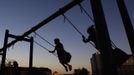 Girls play on swings in a playground in the Chechen capital Grozny April 29, 2013. The naming of two Chechens, Dzhokhar and Tamerlan Tsarnaev, as suspects in the Boston Marathon bombings has put Chechnya - the former site of a bloody separatist insurgency - back on the world's front pages. Chechnya appears almost miraculously reborn. The streets have been rebuilt. Walls riddled with bullet holes are long gone. New high rise buildings soar into the sky. Spotless playgrounds are packed with children. A giant marble mosque glimmers in the night. Yet, scratch the surface and the miracle is less impressive than it seems. Behind closed doors, people speak of a warped and oppressive place, run by a Kremlin-imposed leader through fear. Picture taken April 29, 2013. REUTERS/Maxim Shemetov (Russia - Tags: SOCIETY POLITICS) ATTENTION EDITORS: PICTURE 36 OF 40 FOR PACKAGE 'INSIDE MODERN CHECHNYA'. SEARCH 'REBUILDING CHECHNYA' FOR ALL IMAGES Published: Kvě. 1, 2013, 8:24 dop.