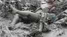 Tourists play in mud during the opening day of the Boryeong Mud Festival at Daecheon beach in Boryeong, about 190 km (118 miles) southwest of Seoul, July 14, 2012. About 2 to 3 million domestic and international tourists visit the beach during the annual festival, according to the festival organisation. REUTERS/Lee Jae-Won (SOUTH KOREA - Tags: SOCIETY TRAVEL TPX IMAGES OF THE DAY) Published: Čec. 14, 2012, 1:19 odp.