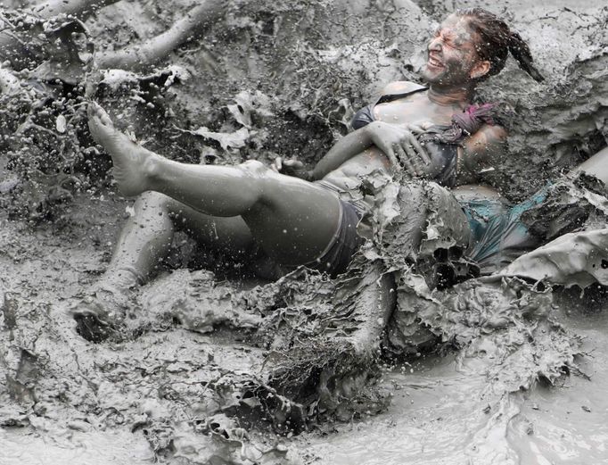 Tourists play in mud during the opening day of the Boryeong Mud Festival at Daecheon beach in Boryeong, about 190 km (118 miles) southwest of Seoul, July 14, 2012. About 2 to 3 million domestic and international tourists visit the beach during the annual festival, according to the festival organisation. REUTERS/Lee Jae-Won (SOUTH KOREA - Tags: SOCIETY TRAVEL TPX IMAGES OF THE DAY) Published: Čec. 14, 2012, 1:19 odp.