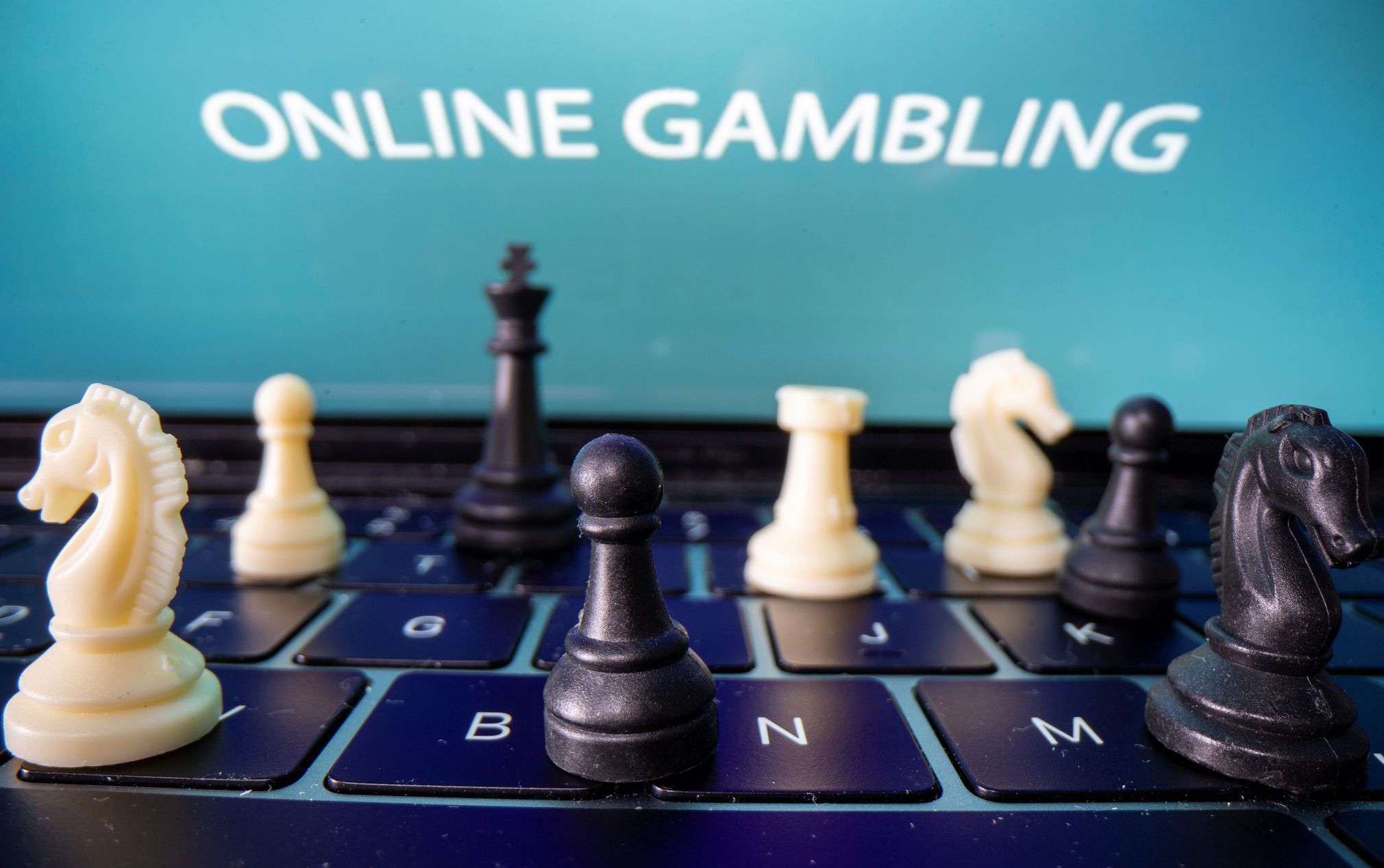 Chess are placed on the keyboard in front of displayed "Online Gambling" words in this illustration picture