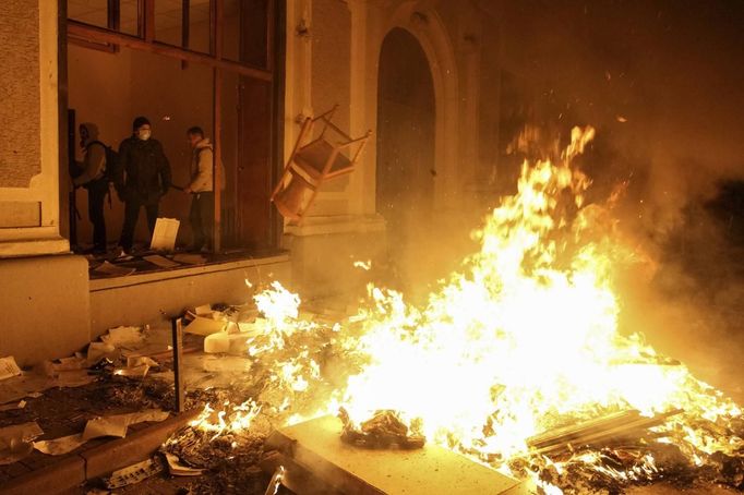 Protivládní demonstranti před zničenou policejní stanicí ve Lvově.