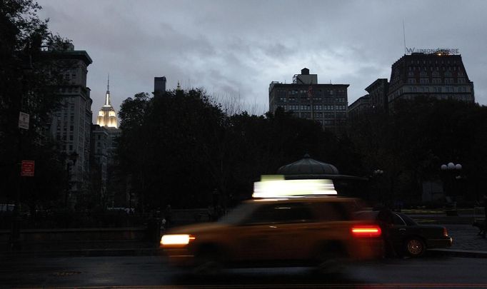 Jedna z mála mrakodrapů, který v New Yorku v noci svítil, byla budova Empire State Building (na snímku vlevo).