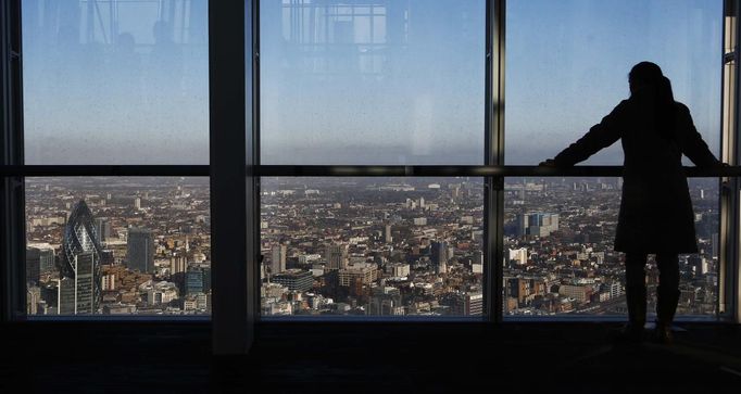 ATTENTION EDITORS - EMBARGOED FOR PUBLICATION TO 00:01 GMT JANUARY 11, 2013 A woman looks over the financial district from a window in The View gallery at the Shard, western Europe's tallest building, in London January 9, 2013. The View, the public viewing deck accessible by high speed elevators on the 309 metre (1013 feet) Shard building, opens on February 1. Picture taken January 9, 2013. REUTERS/Luke Macgregor (BRITAIN - Tags: TRAVEL CITYSCAPE) TEMPLATE OUT Published: Led. 10, 2013, 12:08 odp.