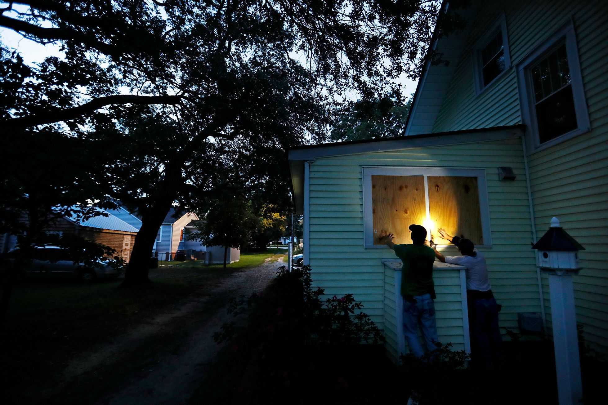 Russell Meadows, left, helps neighbor Rob Muller board up his home ahead of Hurricane Florence in Morehead City, N.C.