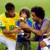 Brazil's Marcelo helps his son hold the trophy as teammate N