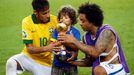 Brazil's Marcelo (R) helps his son hold the trophy as teammate Neymar looks on as they celebrate winning their Confederations Cup final soccer match against Spain at the