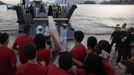 Catholics receive the World Youth Day cross from sailors of the Brazilian Navy during its arrival in Icarai beach in Niteroi near Rio de Janeiro May 19, 2013. Pope Francis will travel to Brazil on his first international trip as pontiff in July. The main purpose of the trip is for the pope to preside at the Catholic Church's World Day of Youth. The pope's participation in World Youth Day events starts on the evening of July 25 in Rio's famed Copacabana Beach area and culminates with a huge open-air Mass in the Guaratiba area of the city on July 28. REUTERS/Ricardo Moraes (BRAZIL - Tags: RELIGION SOCIETY) Published: Kvě. 19, 2013, 10:04 odp.