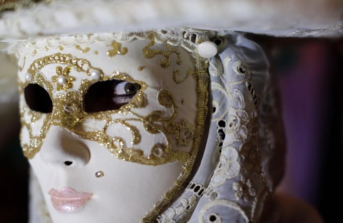 Nadia, wife of Marco Dilauro, looks on as she wears one of his creations, an elaborate costume for the Venice Carnival January 25, 2013. Marco Dilauro, 43, is a tax collector by day, but his real passion is making masks and costumes for the carnival. A resident of Como, northern Italy, he chooses fabrics, ribbons, lace and costume jewellery to make the period costumes after doing extensive research, and wears them at Carnival, which ends on the day before Ash Wednesday. Picture taken January 25, 2013. REUTERS/Alessandro Bianchi (ITALY - Tags: SOCIETY) Published: Led. 27, 2013, 11:55 odp.