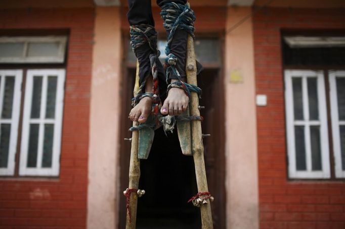 Feet of Drumpal Choudhary, 11, tied with a wooden pole are pictured as he performs his trick at the streets of Kathmandu August 15, 2012. Drumpal, together with his brother, Gchan, and sister, Shivani, came to Kathmandu from India 5 years ago. They earn their living by performing tricks on the streets of Kathmandu. According to Drumpal, Shivani's older brother, they earn around $10 a day by performing tricks, which is not enough to feed their 10-member family living together in a small hut without a proper toilet or any basic needs. REUTERS/Navesh Chitrakar (NEPAL - Tags: SOCIETY POVERTY IMMIGRATION) Published: Srp. 15, 2012, 4:19 odp.