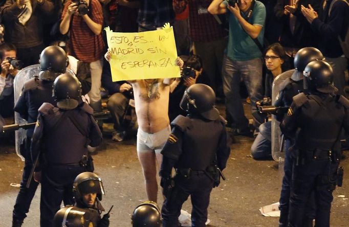 A protester holds a poster during a demonstration outside the Spanish parliament in Madrid, September 25, 2012. Protesters clashed with police in Spain's capital on Tuesday as the government prepares a new round of unpopular austerity measures for the 2013 budget that will be announced on Thursday. The poster reads "This certainly is Madrid without hope". REUTERS/Sergio Perez (SPAIN - Tags: CIVIL UNREST POLITICS BUSINESS) Published: Zář. 25, 2012, 9 odp.