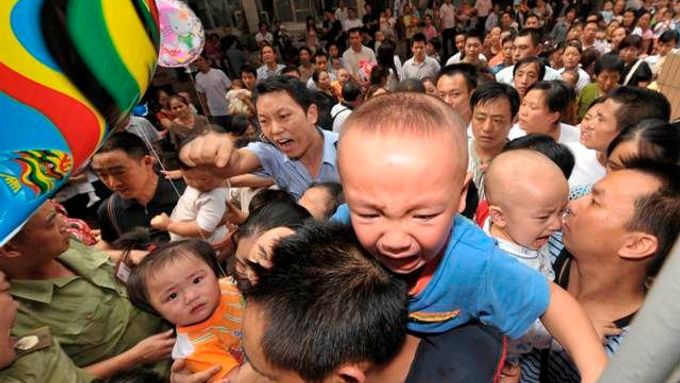 Bezpečnostní složky udržují pořádek před nemocnicí ve městě Čchung-čching. Rodiče se snaží se svými dětmi dostat na lékařské vyšetření, které by odhalilo, zda děti nemají ledvinové kameny.
