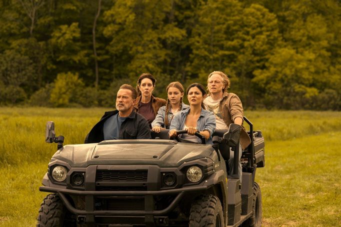 Vepředu sedí Arnold Schwarzenegger jako Luke Brunner a Monica Barbaro v roli Emmy Brunner.