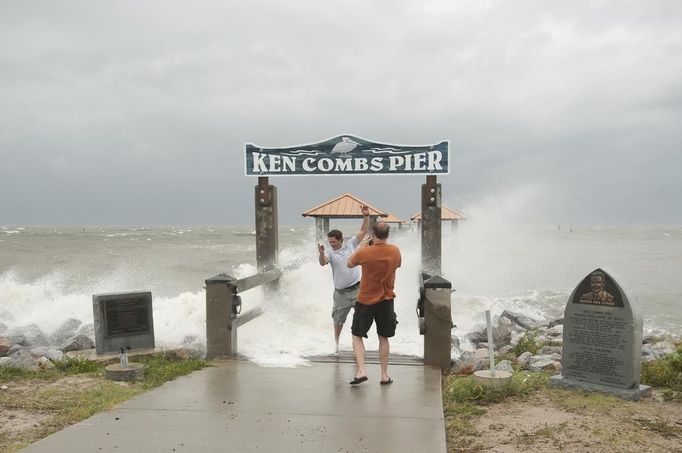 Steven Saia gets hit with a wave while Scott Burley takes his photo at the Ken Combs Pier as Hurricane Isaac approaches Gulfport, Mississippi, August 28, 2012. Photo taken August 28, 2012. REUTERS/Michael Spooneybarger (UNITED STATES - Tags: ENVIRONMENT DISASTER) Published: Srp. 29, 2012, 11:10 dop.