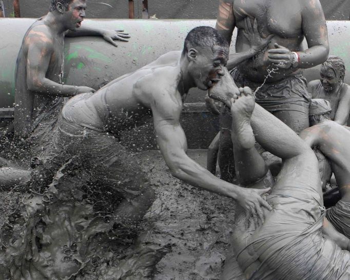 Tourists play in mud during the opening day of the Boryeong Mud Festival at Daecheon beach in Boryeong, about 190 km (118 miles) southwest of Seoul, July 14, 2012. About 2 to 3 million domestic and international tourists visit the beach during the annual festival, according to the festival organisation. REUTERS/Lee Jae-Won (SOUTH KOREA - Tags: SOCIETY TRAVEL TPX IMAGES OF THE DAY) Published: Čec. 14, 2012, 1:22 odp.