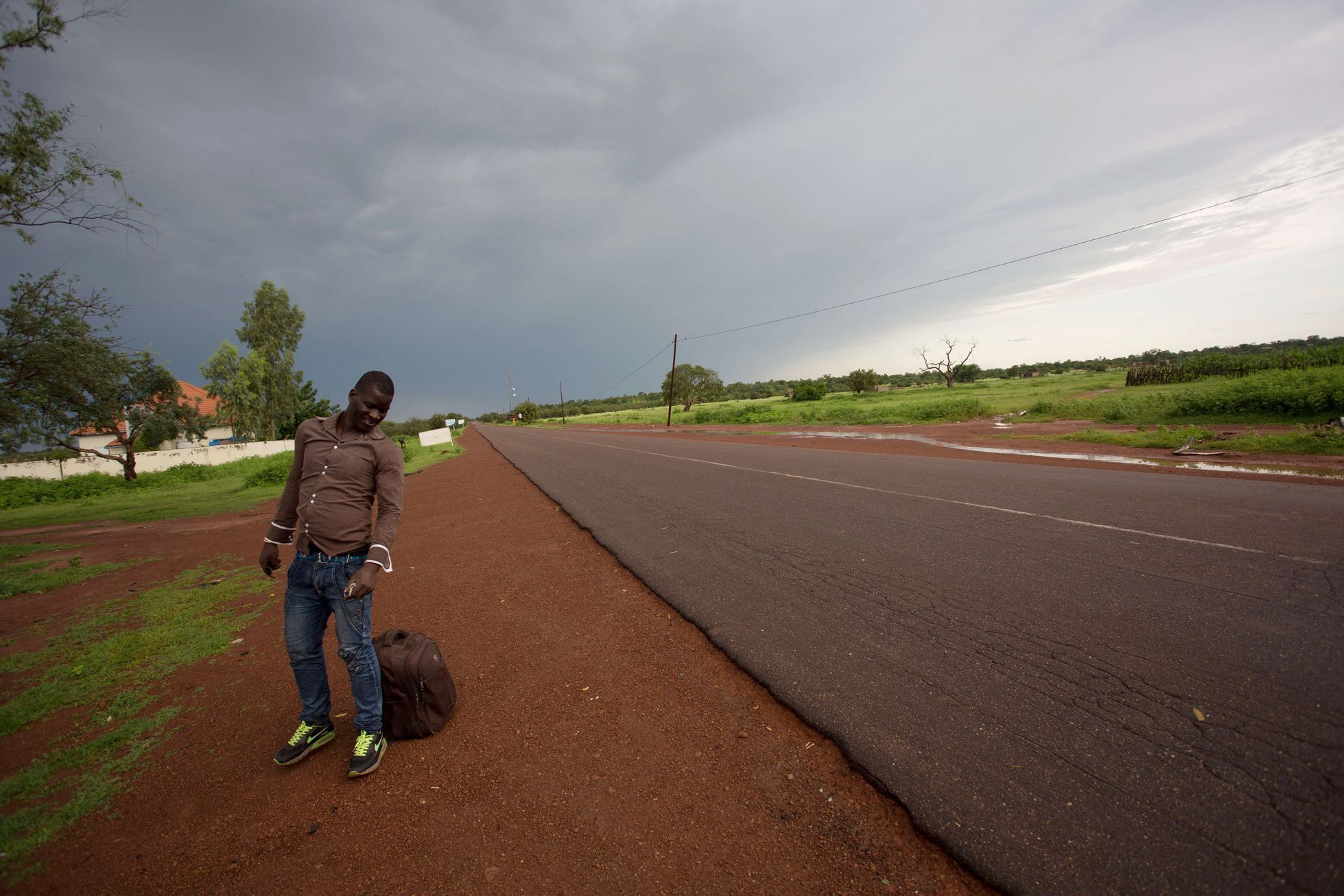 Senegal. Mladý muž čeká na autobus v Goudiry