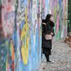 Lennonova zeď po třech měsících od malování - turisté, graffiti
