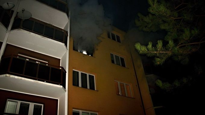 Z okna hořícího bytu se valil hustý kouř.