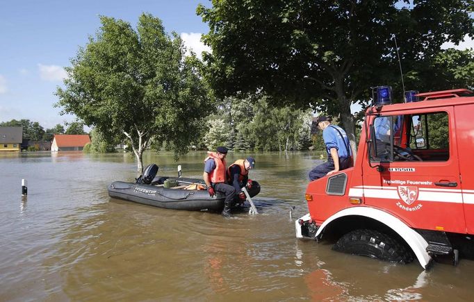 Firefighters move a boat into the water to search for residents after the river Elbe flooded the village of Kabelitz, north of Magdeburg June 10, 2013. Tens of thousands of people have been forced to leave their homes and there have been at least a dozen deaths as a result of floods that have hit Germany, Austria, Slovakia, Poland and the Czech Republic over the past week. REUTERS/Fabrizio Bensch (GERMANY - Tags: DISASTER ENVIRONMENT)