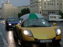 Náhlé průtrže donutily cestující k nestandardním řešením - deštník nad kabrioletem.