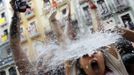 A reveller gets soaked in water thrown from a balcony during the start of the San Fermin Festival in Pamplona July 6, 2012. The annual festival, best known for its daily running of the bulls, kicked off on Friday with the traditional "Chupinazo" rocket launch and will run until July 14. REUTERS/Susana Vera (SPAIN - Tags: SOCIETY TRAVEL TPX IMAGES OF THE DAY) Published: Čec. 6, 2012, 12:27 odp.