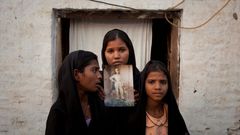 Dcery vězněné Pákistánky Asii Bibiové pózují s fotografií matky