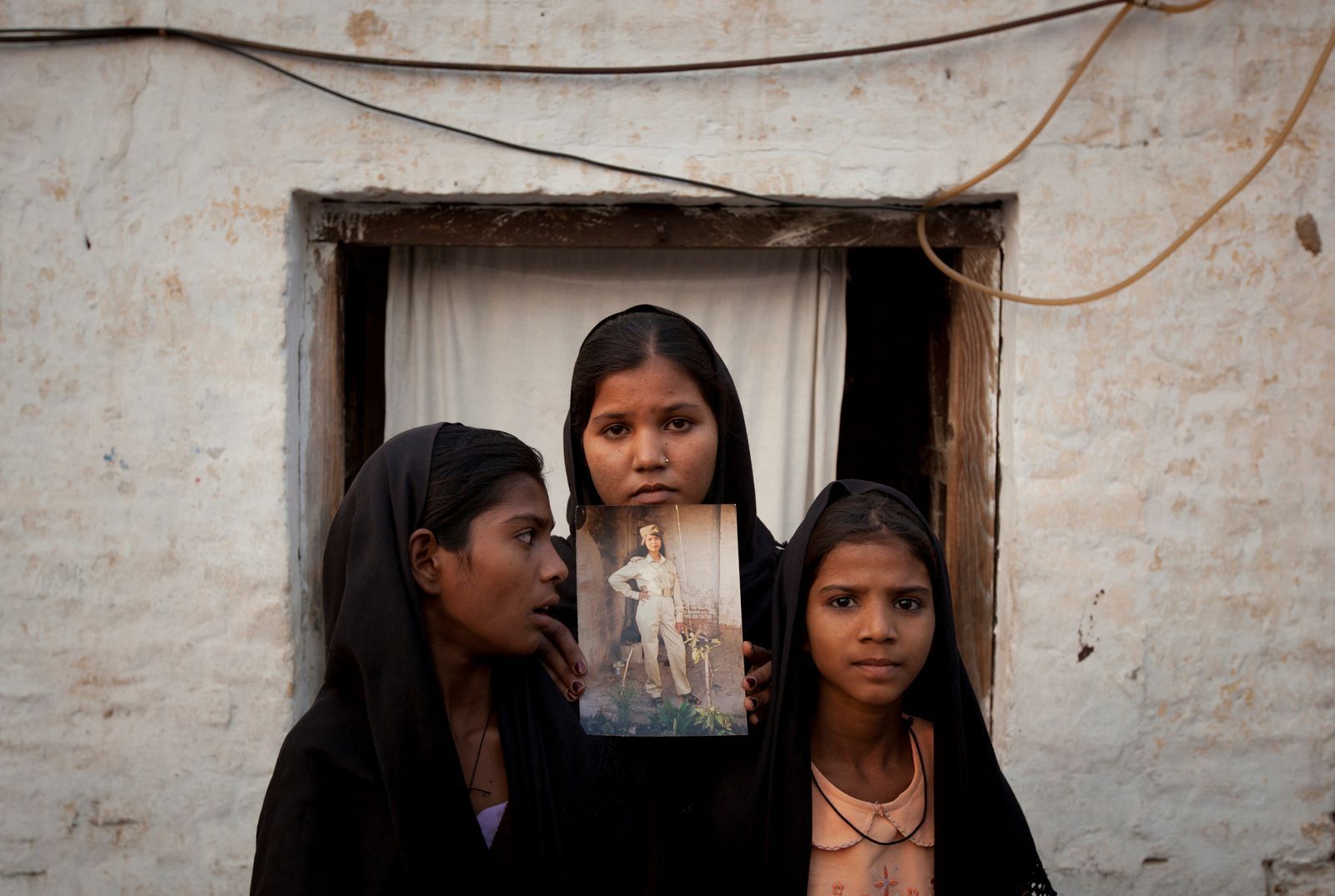 Dcery vězněné Pákistánky Asii Bibiové pózují s fotografií matky