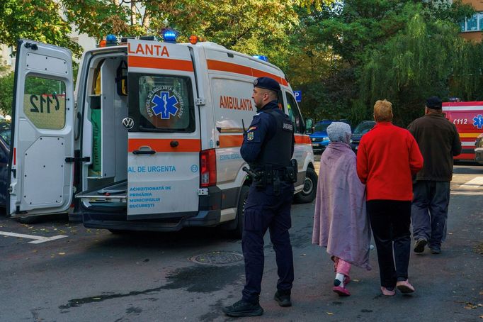 Policista stojí vedle sanitky poblíž místa výbuchu v bytovém domě v Bukurešti, Rumunsko, 17. října 2025.