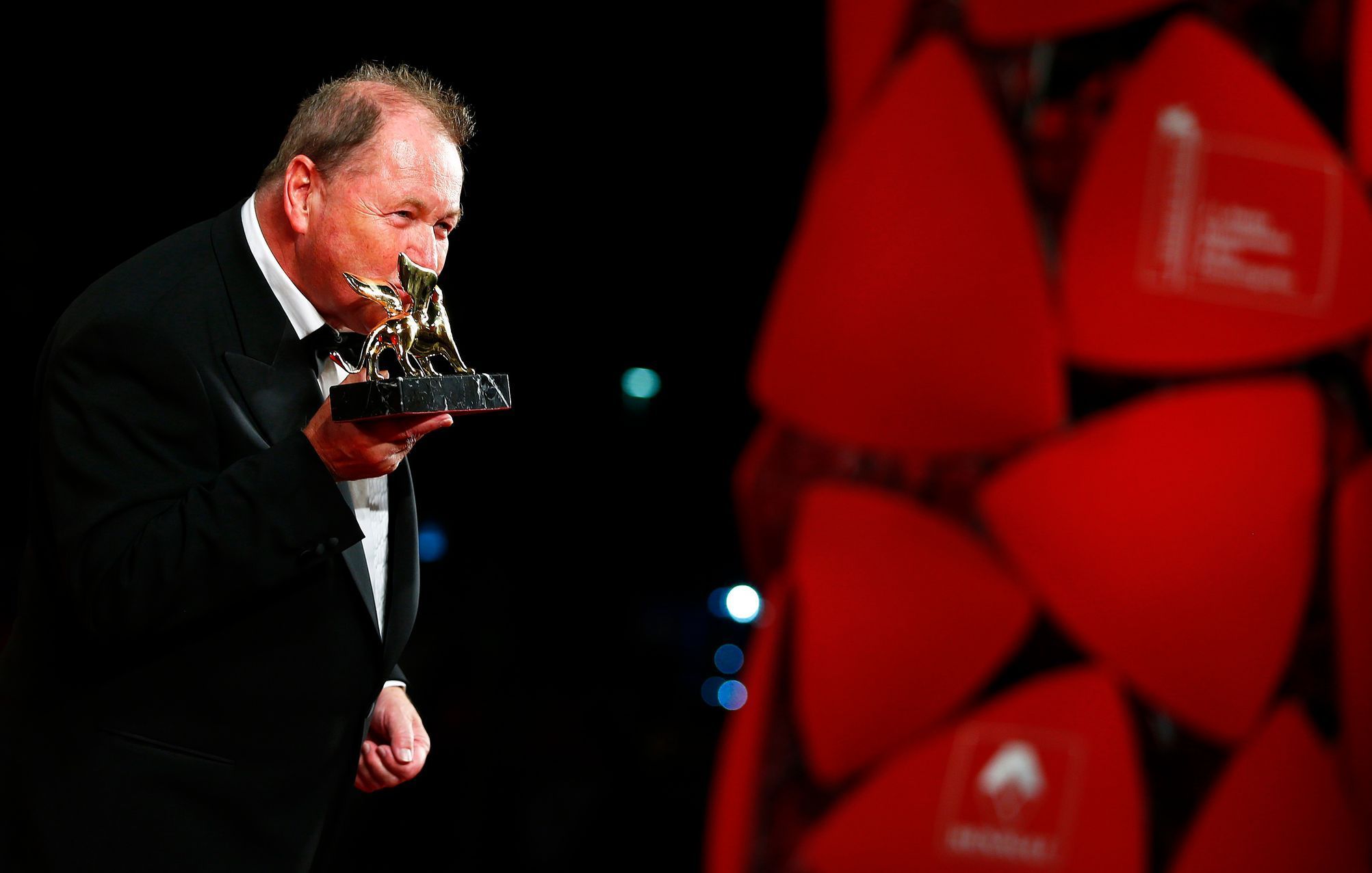 Swedish director Roy Andersson kisses his Golden Lion prize for his movie &quot;A Pigeon Sat on a Branch Reflecting on Existence&quot; during the award ceremony at the 71st Venice Film Festival