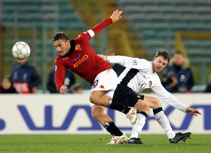 Hráč AS Řím Francesco Totti bojuje o míč s Johnny Evansem z Manchesteru United