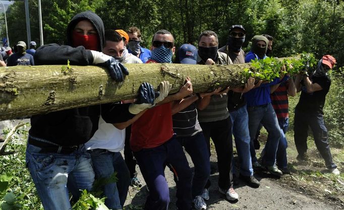 Coal miners move a tree trunk to make a barricade on motorway A-66 to protest against government spending cuts in the mining sector in Campomanes, near Oviedo, northern Spain, May 30, 2012. REUTERS/Eloy Alonso (SPAIN - Tags: CIVIL UNREST BUSINESS EMPLOYMENT TPX IMAGES OF THE DAY) Published: Kvě. 30, 2012, 3:18 odp.