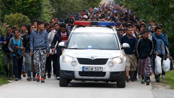 Maďarští policisté doprovázejí uprchlíky.