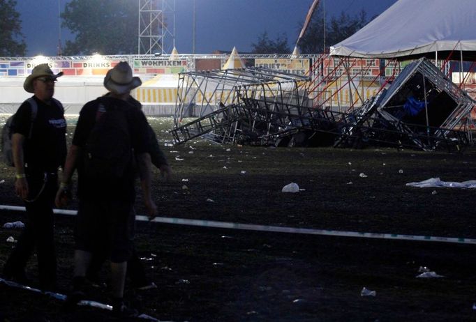 Dobrovolníci přihlížejí na trosky stanu, který strhla bouře během velkého hudebního festivalu v Belgii