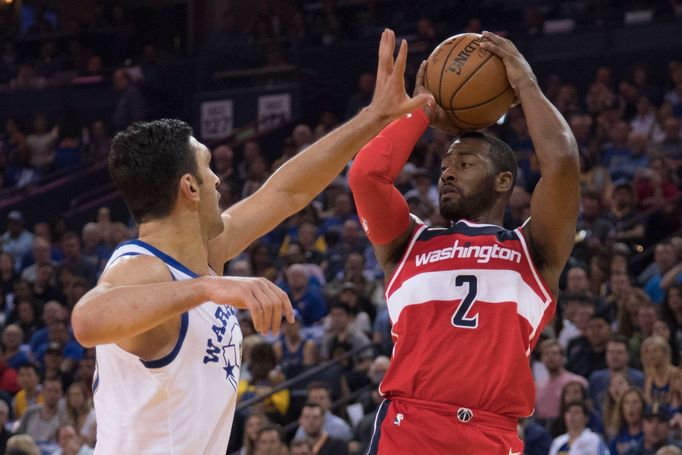 John Wall z Washingtonu při utkání s Golden State, brání ho Zazu Pačulija