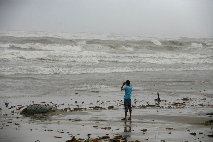 Muž pozoruje vlny na Bagdad beach v Matamoros, Mexiko.