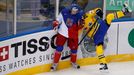 Jan Kolar of the Czech Republic (L) checks Sweden's Nicklas Danielsson (R) to the boards during the first period of their men's ice hockey World Championship Group A game