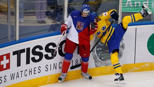 Jan Kolar of the Czech Republic (L) checks Sweden's Nicklas Danielsson (R) to the boards during the first period of their men's ice hockey World Championship Group A game