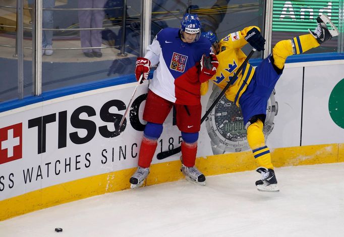 Jan Kolar of the Czech Republic (L) checks Sweden's Nicklas Danielsson (R) to the boards during the first period of their men's ice hockey World Championship Group A game