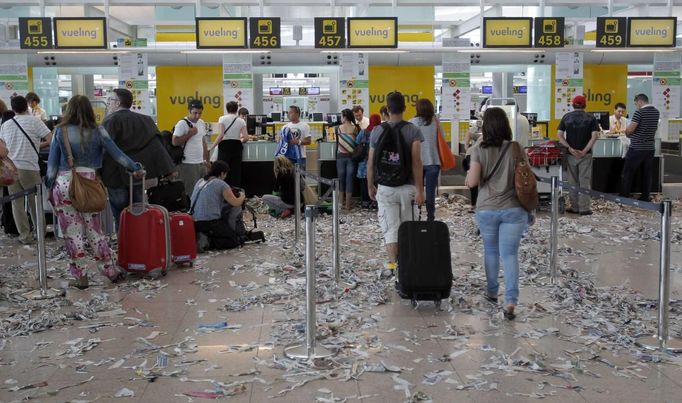 Passengers queue in front of check-in desks during a protest by the cleaning staff at Barcelona's airport May 29, 2012. Cleaning staff working for a company which has a contract with the airport demonstrated against pay and benefits cuts made by their employer. REUTERS/Albert Gea (SPAIN - Tags: CIVIL UNREST BUSINESS TRANSPORT) Published: Kvě. 29, 2012, 5:08 odp.