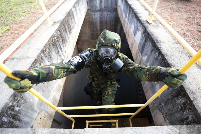 A Brazilian army soldier wearing a chemical suit participates in an anti-terror simulation exercise as part of the preparation for the upcoming 2013 FIFA Confederations Cup in Brasilia. May 22, 2013. About 100 soldiers took part in the exercise which include preventive strikes against chemical, biological and radiological weapons conducted around Mane Garrincha National Stadium, according to an official statement. REUTERS/Ueslei Marcelino (BRAZIL - Tags: SPORT SOCCER MILITARY) Published: Kvě. 22, 2013, 9:42 odp.