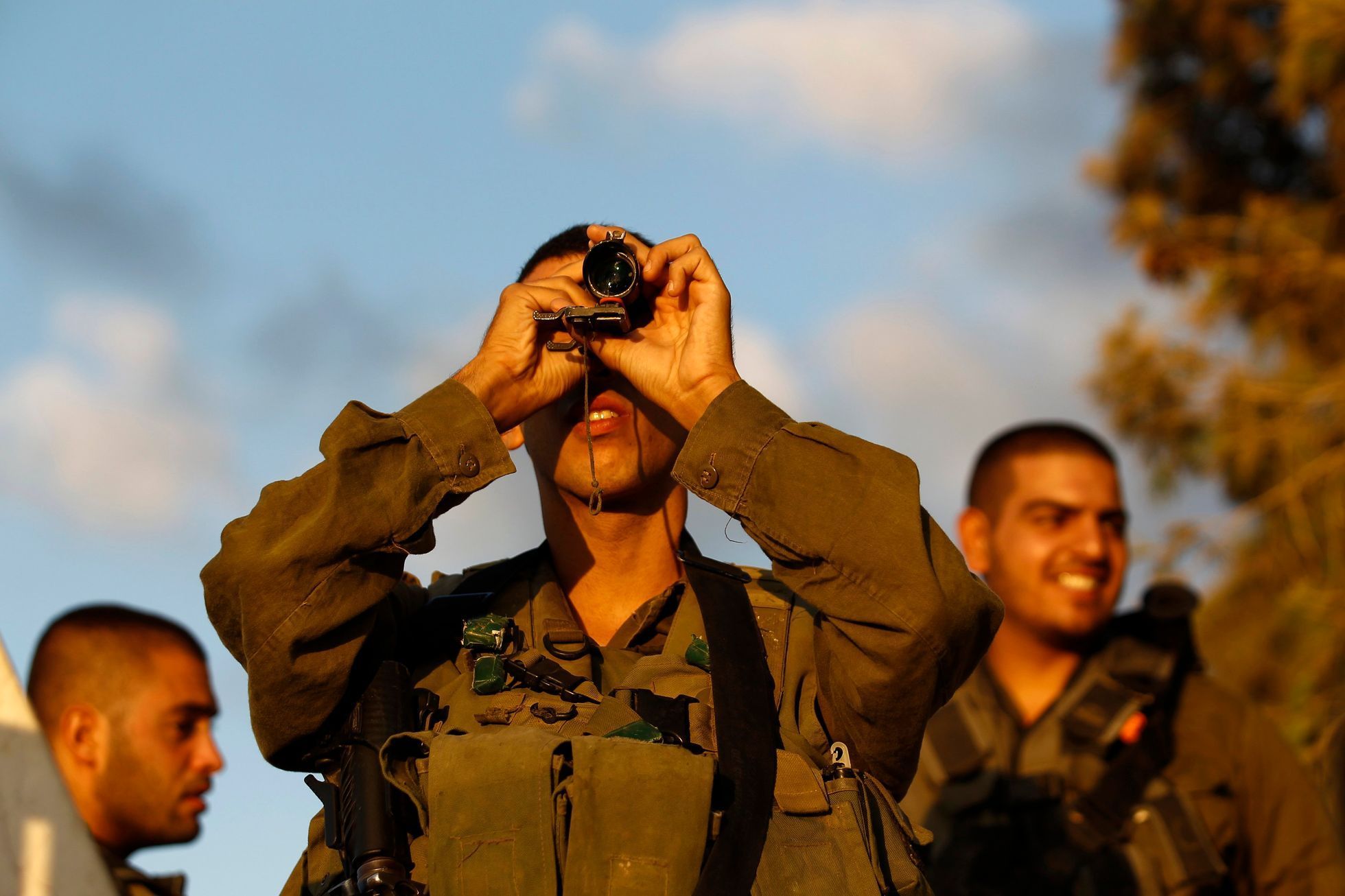 An Israeli soldier looks at the Gaza Strip through a monocular on the Israeli border