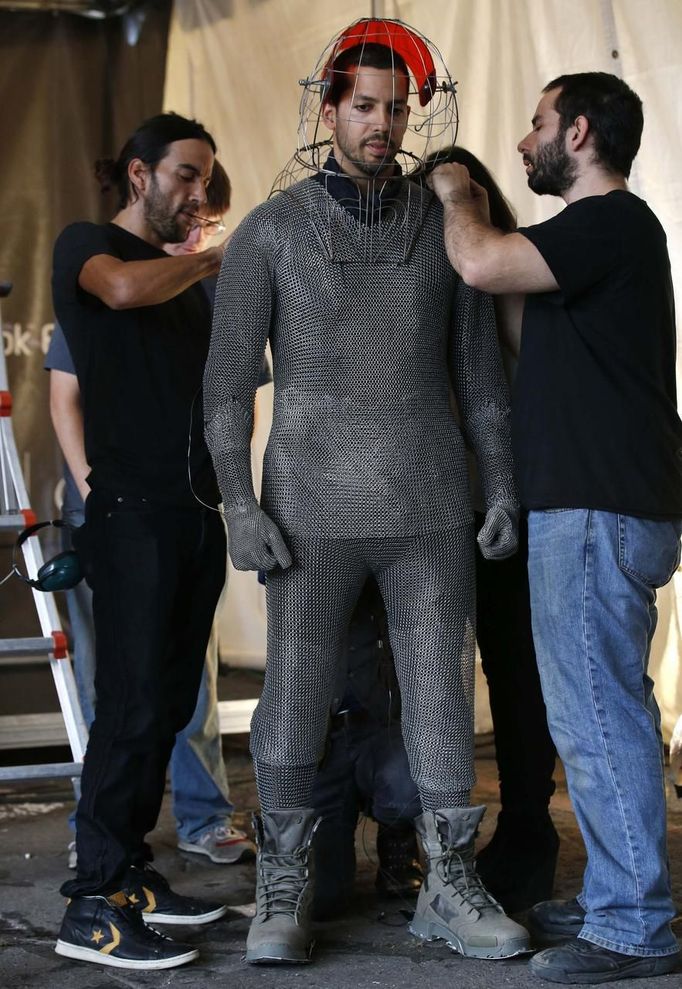 Magician David Blaine is fitted with a metal suit and head cage before a demonstration of his upcoming performance "Electrified" during a press briefing in New York, October 2, 2012. During the performance Blaine will wear a custom made metal suit and will stand on a 20-foot-high (6 meter) platform on New York City's Pier 54 on the edge of the Hudson River while surrounded by seven metallic orbs, or tesla coils, that will stream 1 million volts of electricity around him for 3 days and nights. REUTERS/Mike Segar (UNITED STATES - Tags: ENTERTAINMENT SOCIETY) Published: Říj. 2, 2012, 7:01 odp.