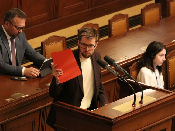 Předseda pirátských poslanců Jakub Michálek ve chvíli, kdy "udělil" ministrovi spravedlnosti Pavlu Blažkovi červenou kartu.