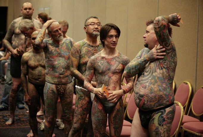 Jeff Bitting (R), from St Augustine, Florida, speaks backstage with fellow full-body tattoo contestants before judging at the National Tattoo Association Convention in Cincinnati, Ohio April 13, 2012. In his 33 years of getting tattoos, Bitting says he has had about 500 hours of work and will complete his other leg in his bid to win more full-body contests. Picture taken April 13, 2012. REUTERS/Larry Downing (UNITED STATES - Tags: SOCIETY TPX IMAGES OF THE DAY) ATTENTION EDITORS PICTURE 21 31 FOR PACKAGE 'ADDICTED TO NEEDLE' TO FIND ALL PICTURES SEARCH 'ADDICTED NEEDLE' Published: Čer. 29, 2012, 2:24 odp.