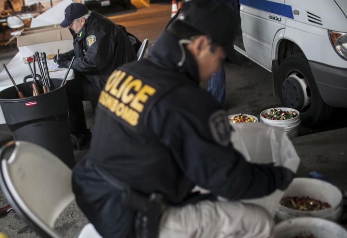 The Seattle Police Department sorts guns and ammunition under I-5 during a gun buyback event in Seattle, Washington January 26, 2013. Participants received up to a $100 gift card in exchange for working handguns, shotguns and rifles, and up to a $200 gift card for assault weapons. The event lasted from 9 a.m. until shortly after noon, after the event ran out of $80,000 worth of gift cards. REUTERS/Nick Adams (UNITED STATES - Tags: POLITICS CIVIL UNREST) Published: Led. 27, 2013, 12:48 dop.