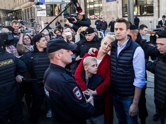 Alexej Navalnyj a vedle něj policisté - častý a typický obrázek.