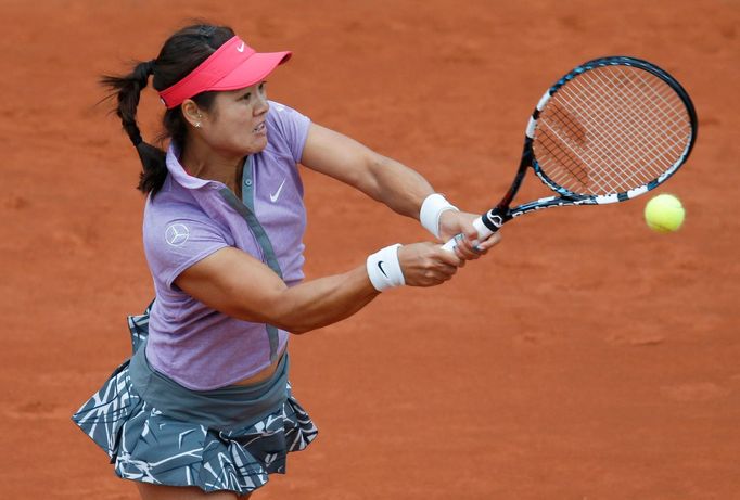 Li Na of China returns a backhand to Kristina Mladenovic of France during their women's singles match at the French Open tennis tournament at the Roland Garros stadium in