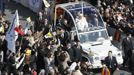 Pope Benedict XVI waves from his Popemobile as he rides through a packed Saint Peter's Square at the Vatican during his last general audience, February 27, 2013. The weekly event which would normally be held in a vast auditorium in winter, but has been moved outdoors to St. Peter's Square so more people can attend. The pope has two days left before he takes the historic step of becoming the first pontiff in some six centuries to step down instead of ruling for life. REUTERS/Tony Gentile (VATICAN - Tags: RELIGION) Published: Úno. 27, 2013, 10:07 dop.