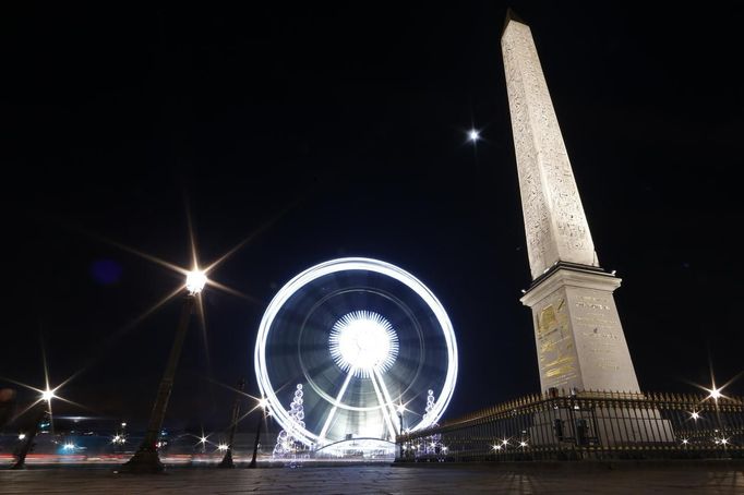 Obří ruské kolo rozsvítilo noční oblohu poblíž Obelisku na Place de la Concorde v Paříži.