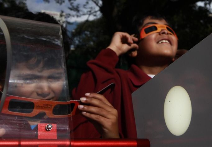 Schoolchildren look at the planet Venus transiting across the sun at Sydney's Observatory June 6, 2012. The planet Venus made a slow transit across the face of the sun on Tuesday, the last such passing that will be visible from Earth for 105 years. REUTERS/Daniel Munoz (AUSTRALIA - Tags: ENVIRONMENT SCIENCE TECHNOLOGY SOCIETY) Published: Čer. 6, 2012, 4:04 dop.